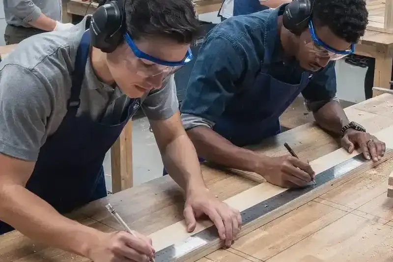 Students collaborating on a technical task in a classroom setting, illustrating communication and problem-solving in career and technical education